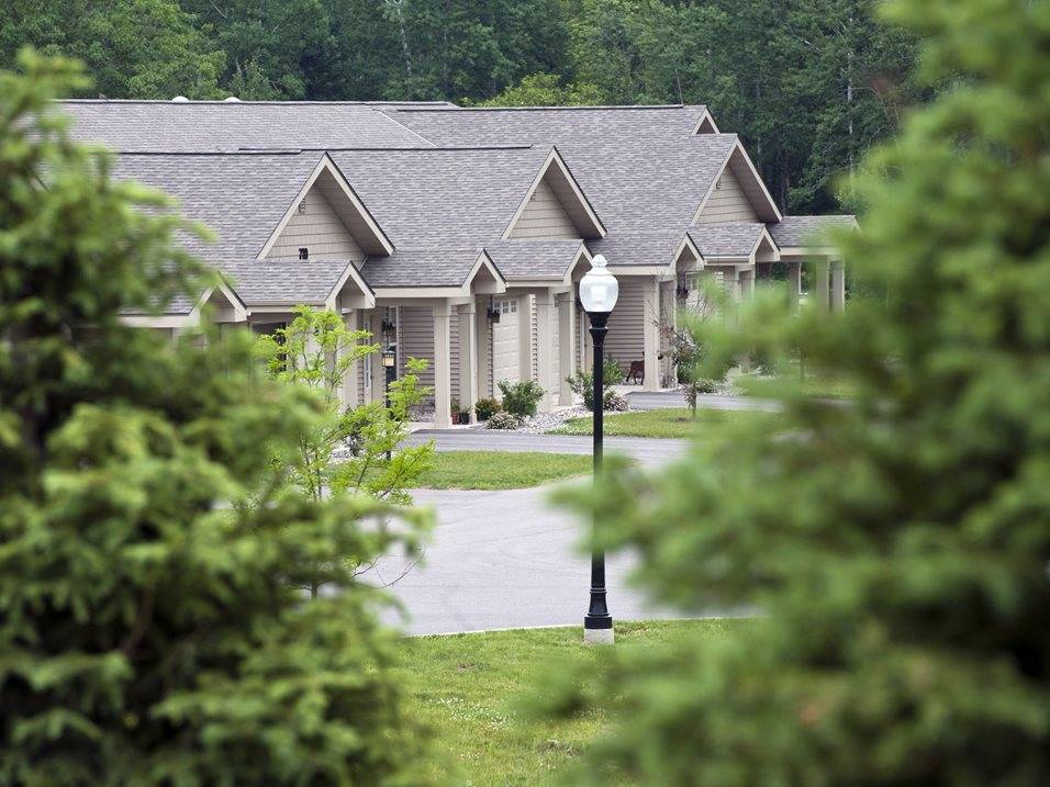 A house with a grey roof and a lamp post in front.