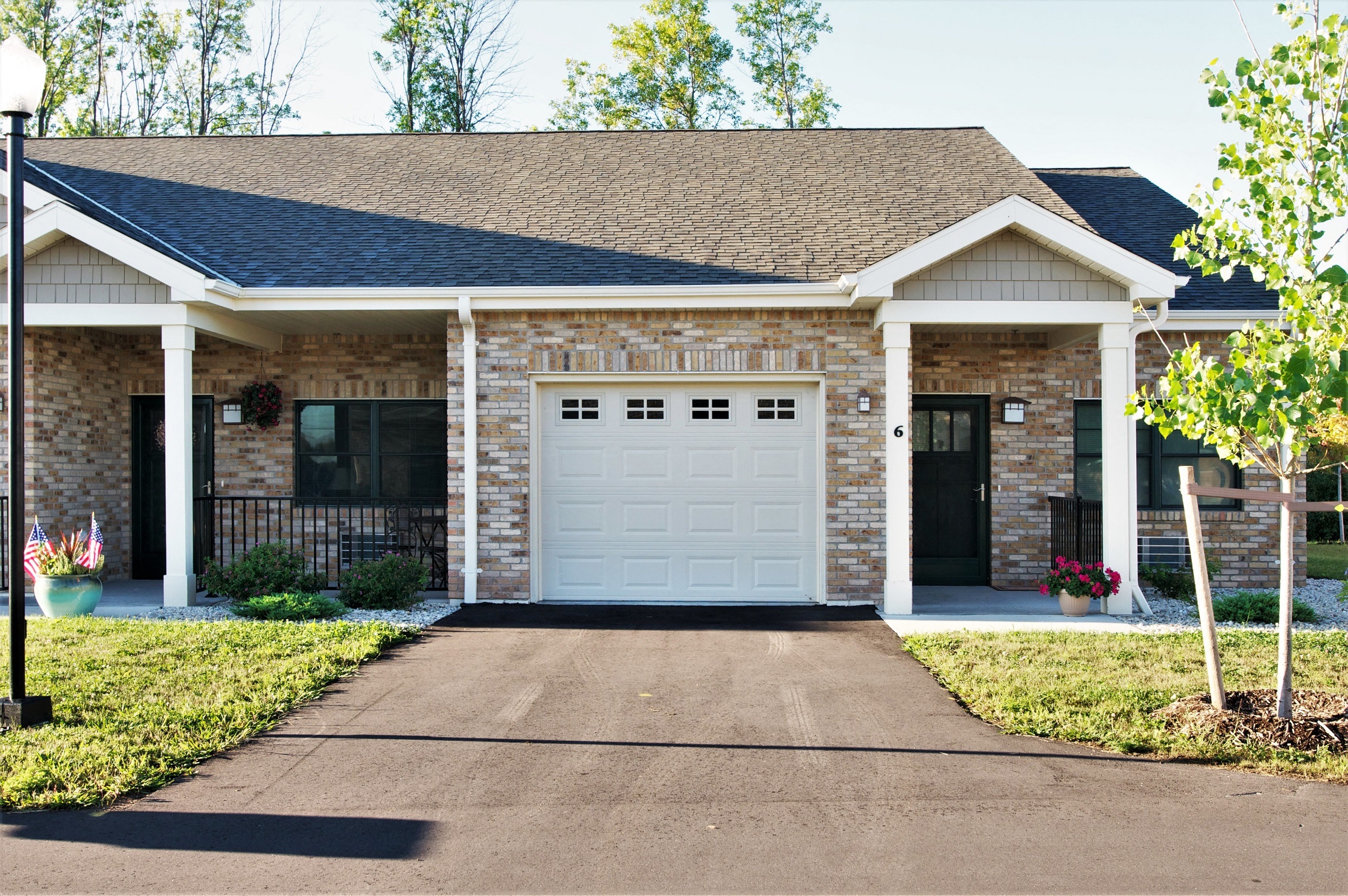 A house with a white garage door and a black gate.