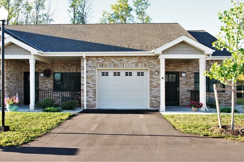 A house with a white garage door and a black gate.