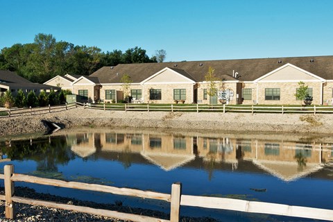 A row of houses with a pond in front.