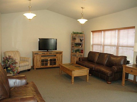A living room with a brown leather couch and a wooden coffee table.