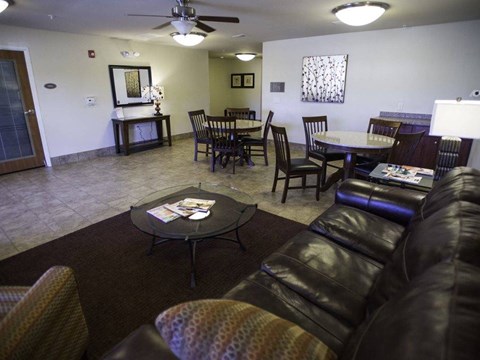 A living room with a black leather couch and a coffee table.