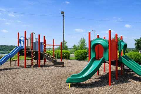 A playground with a red and green slide.