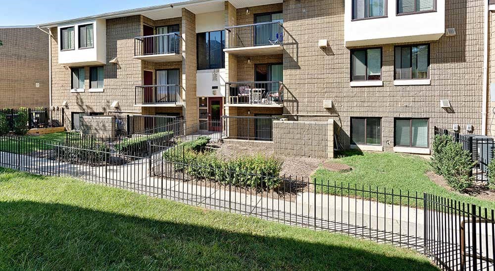 Apartment building with a black fence in front.