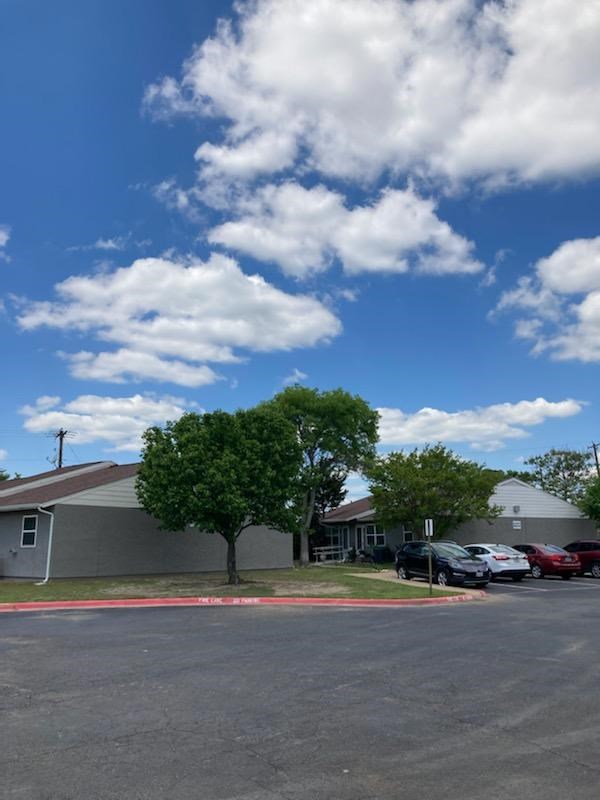 A parking lot with cars and a building in the background.