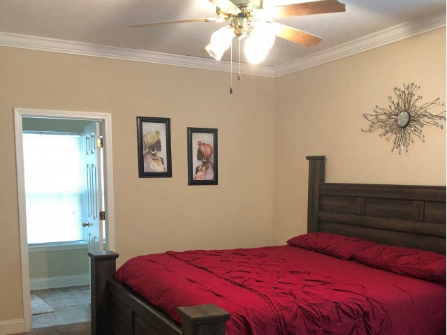 a bedroom with a bed and a ceiling fan