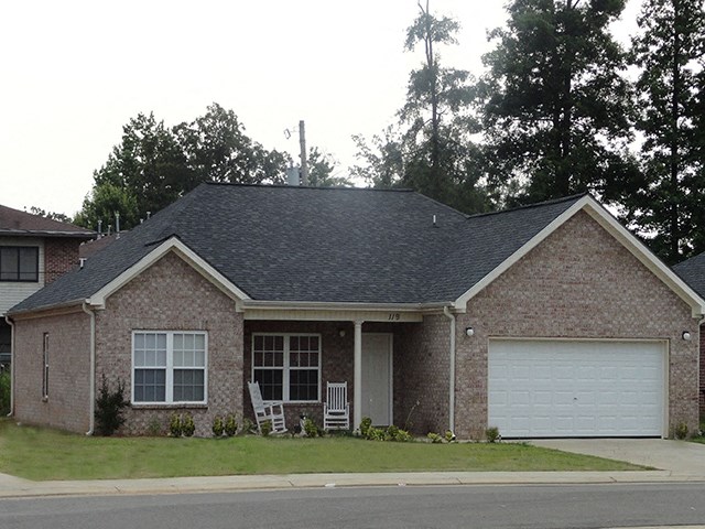 a brick house with a lawn and a white garage door
