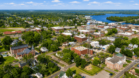 A small town with a waterfront and a church with a steeple.