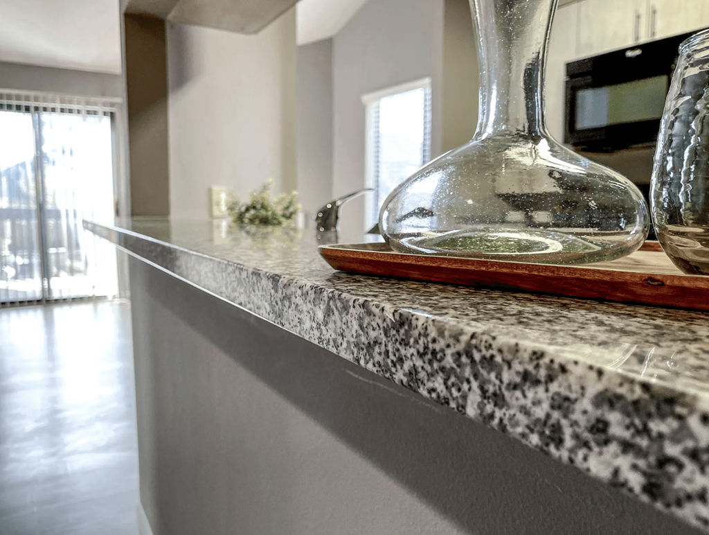 a kitchen counter top with a glass vase on it