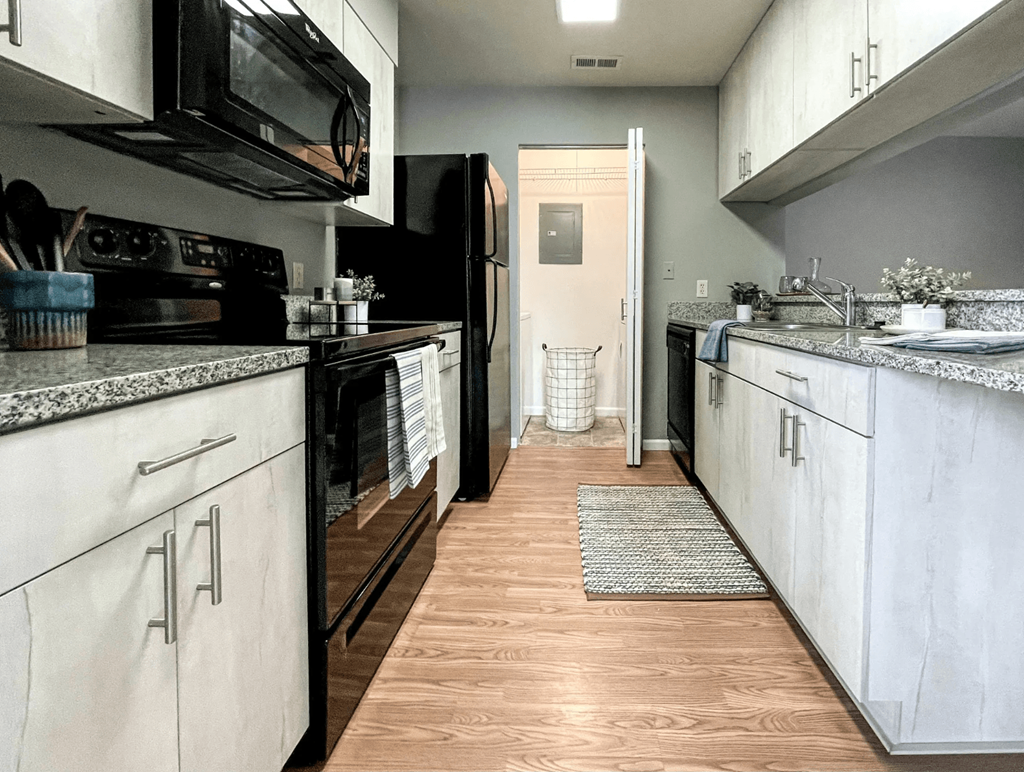 a kitchen with white cabinets and a black stove and refrigerator