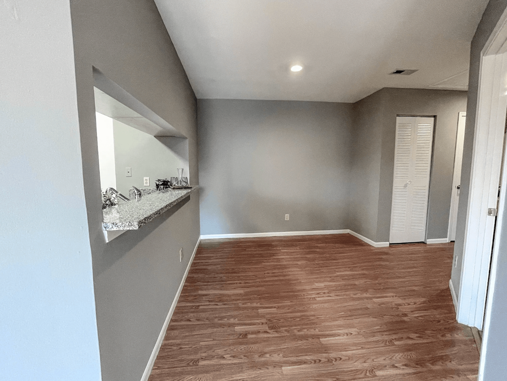 an empty living room with a sink and a mirror