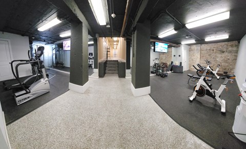 A gym with a variety of exercise equipment including treadmills, stationary bikes, and weights.at Convent Gardens Apartments, Missouri