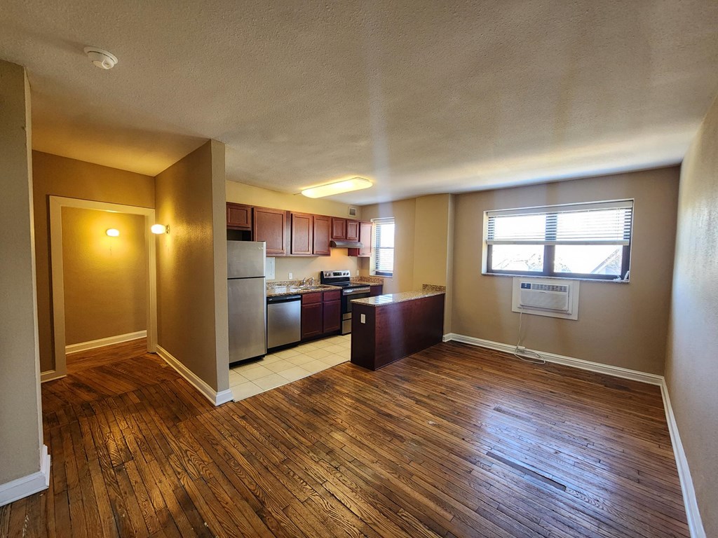 A kitchen with wooden floors and a refrigerator.at Convent Gardens Apartments, Missouri, 63108