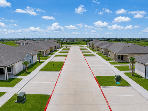 A long row of houses with a red line down the middle of the driveway.