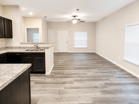 A kitchen with black cabinets and a marble countertop.