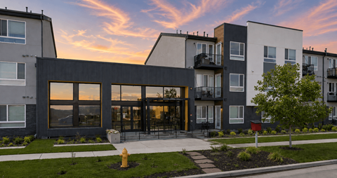 A modern apartment complex with a fire hydrant in front.