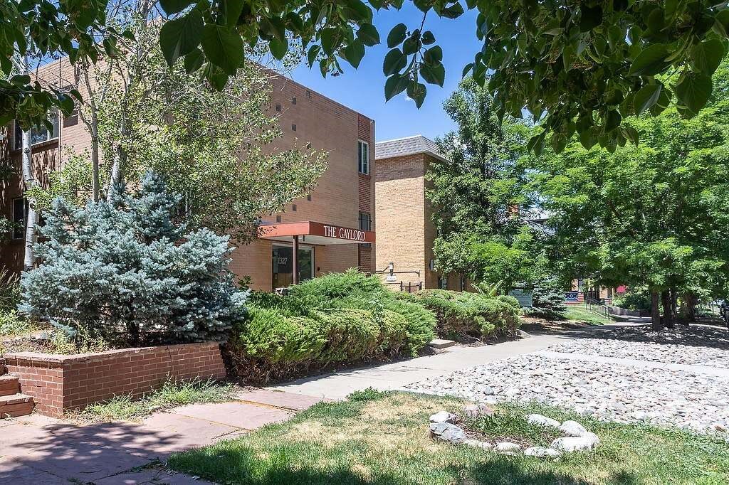 A building with a sign that says "The Canyon" is surrounded by trees and bushes.