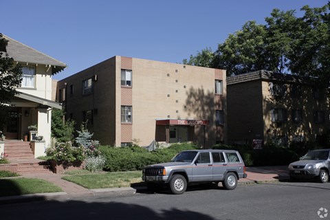 A car is parked on the street in front of a building with a sign that reads "The Waldo.".