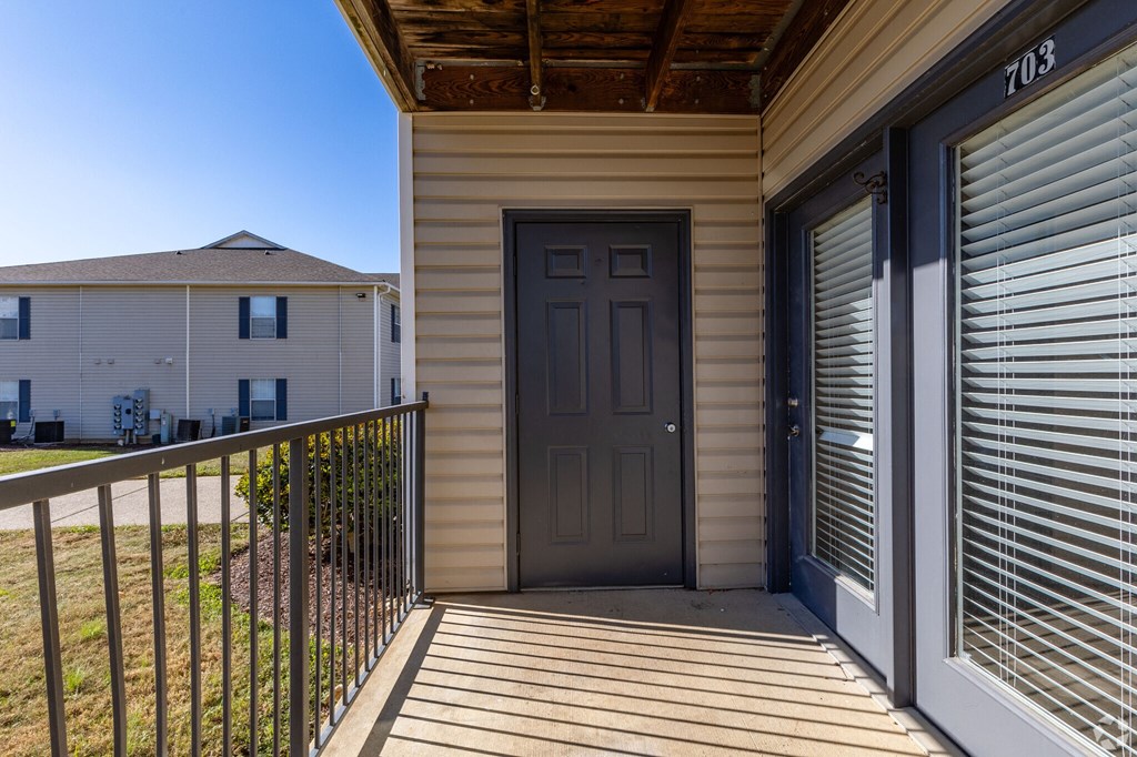 A house numbered 703 with a brown door and a closed grey shuttered window.