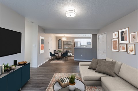 A living room with a grey couch and a television on the left side.