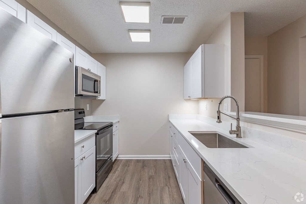 A modern kitchen with white appliances and cabinets.