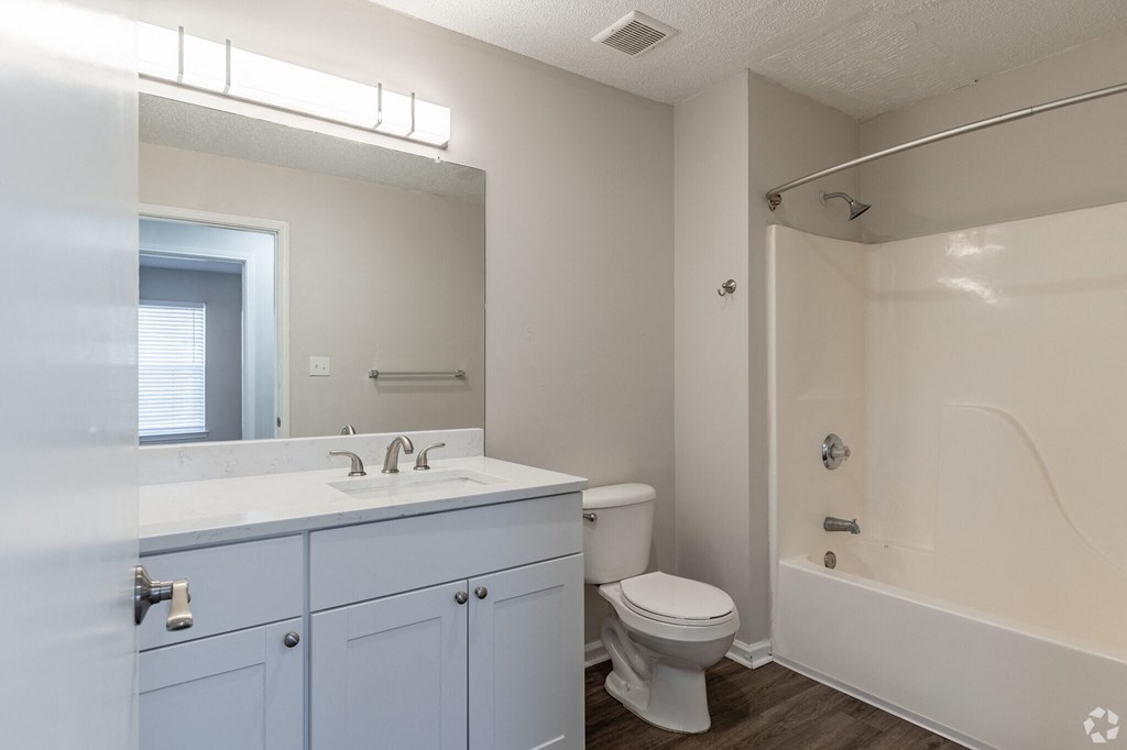 A white bathroom with a toilet, sink, and bathtub.