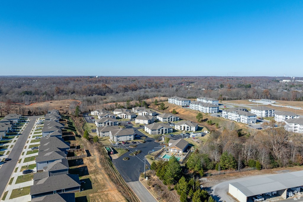 A bird's eye view of a residential area with houses and a parking lot.