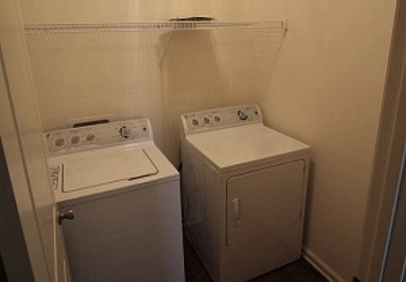 two washing machines in a small room with a door