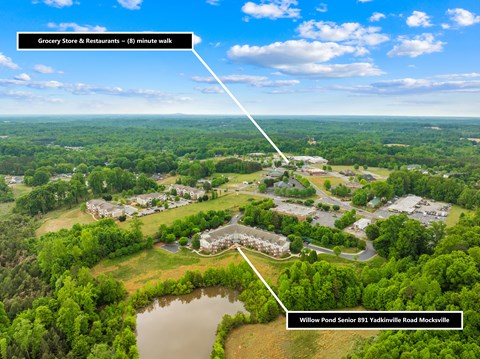 A bird's eye view of Willow Pond Senior Housing and a grocery store and restaurants 8 minutes away.