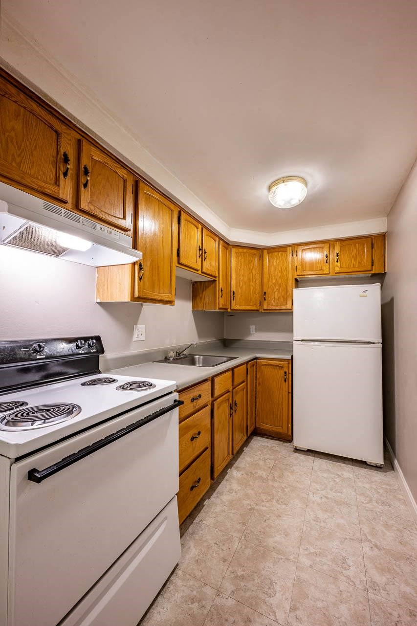 a kitchen with white appliances and wooden cabinets