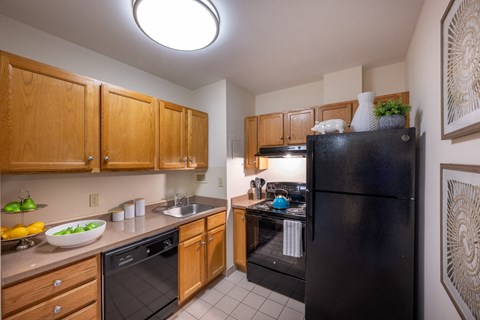 a kitchen with black appliances and wooden cabinets