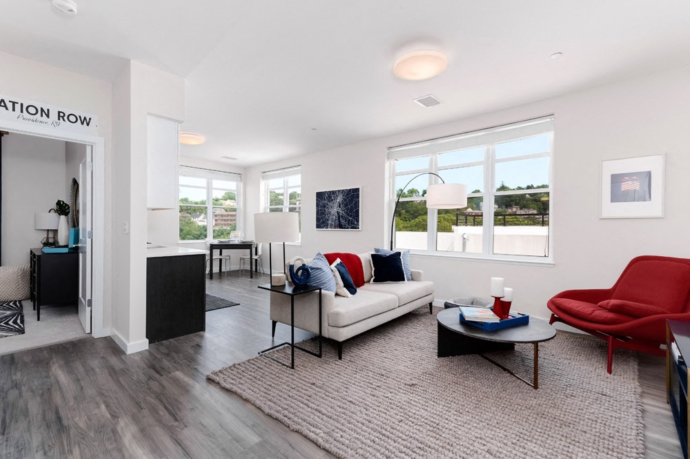 Model apartment with open concept floor plan, large windows, carpet