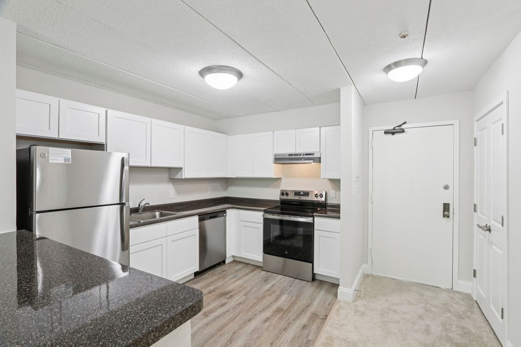 A kitchen with white cabinets and stainless steel appliances.