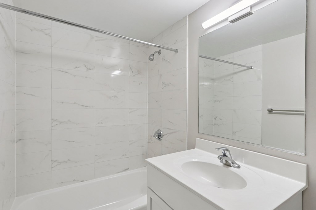 A white sink in a bathroom with a marble tile wall.