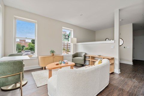 A living room with a white couch and a green chair.
