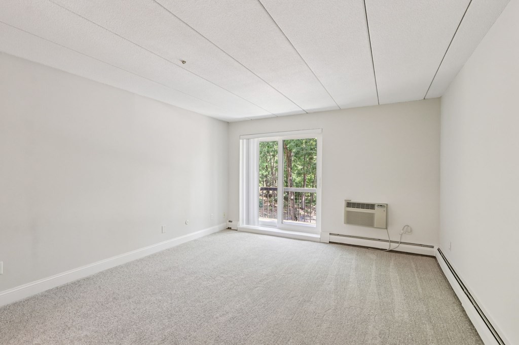 A room with a carpeted floor and a window.