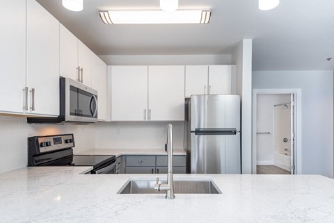 a kitchen with white cabinets and a stainless steel refrigerator