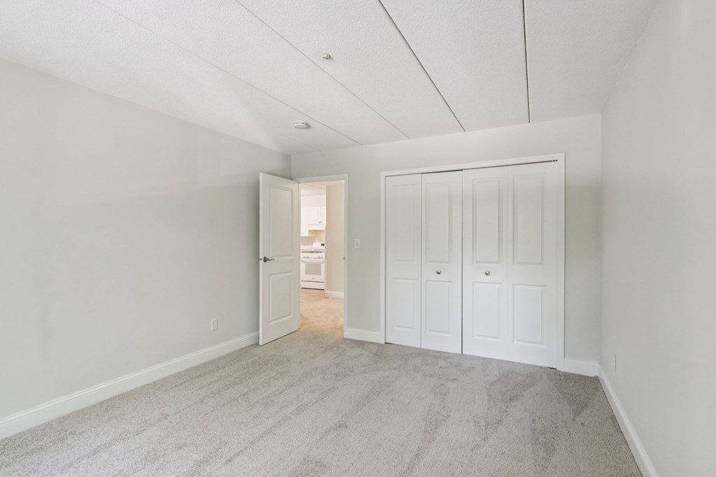 A room with a carpeted floor and white walls.
