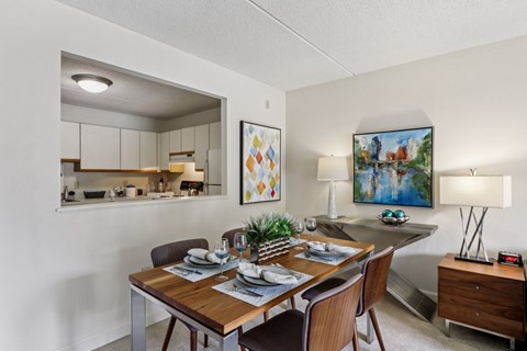 A dining room with a wooden table set for two.