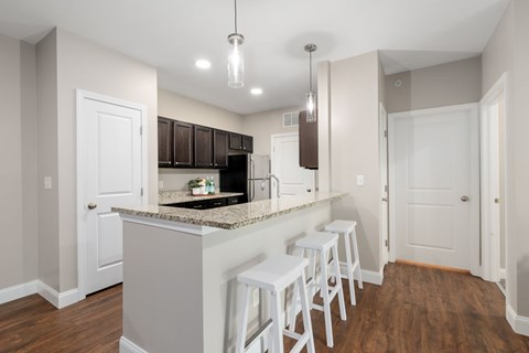 A kitchen with white cabinets and a granite countertop.