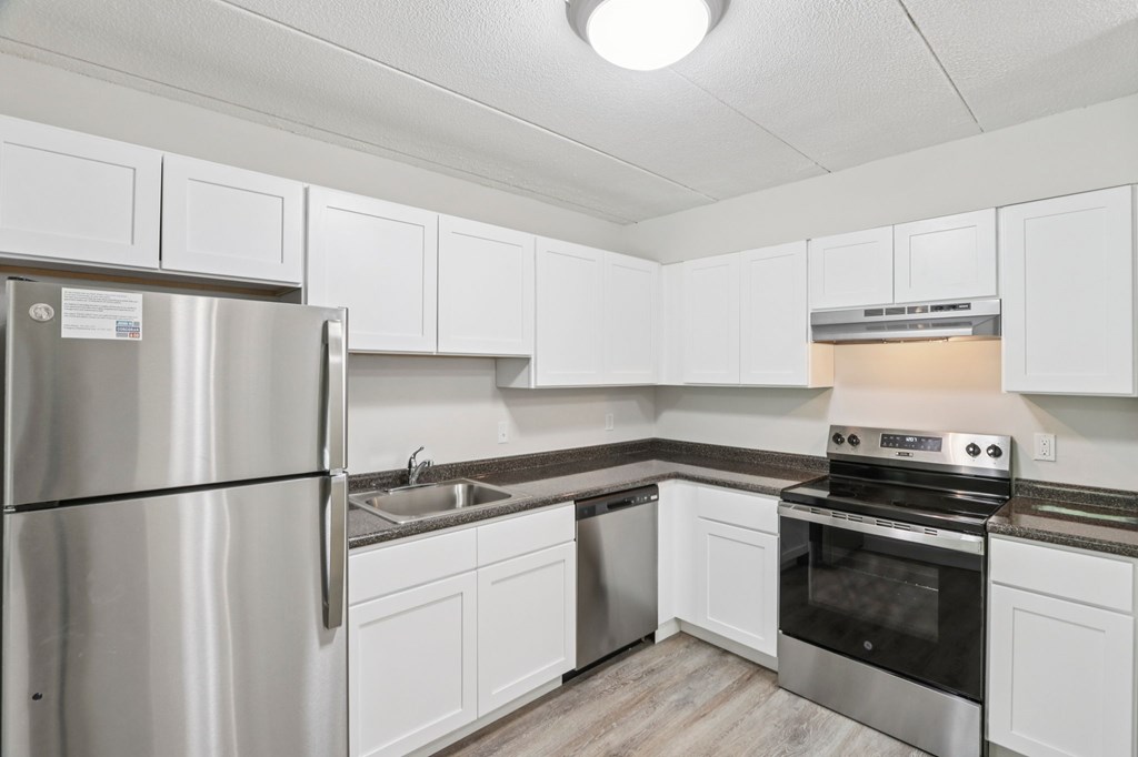 A kitchen with white cabinets and stainless steel appliances.