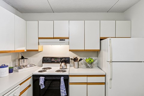A kitchen with a black stove top oven and white cabinets.