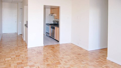 Entryway and living area with parquet floors and a view into the updated kitchen.