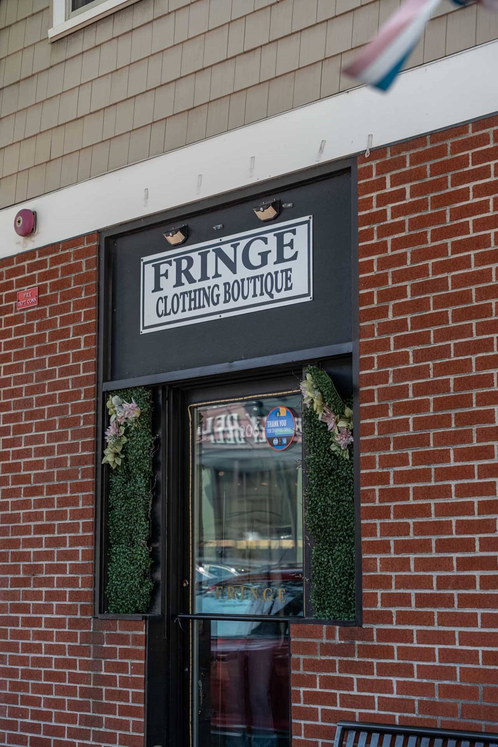 A storefront with a sign that says Fringe Clothing Boutique.