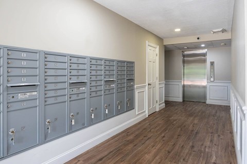 A row of mailboxes are lined up on a wall.