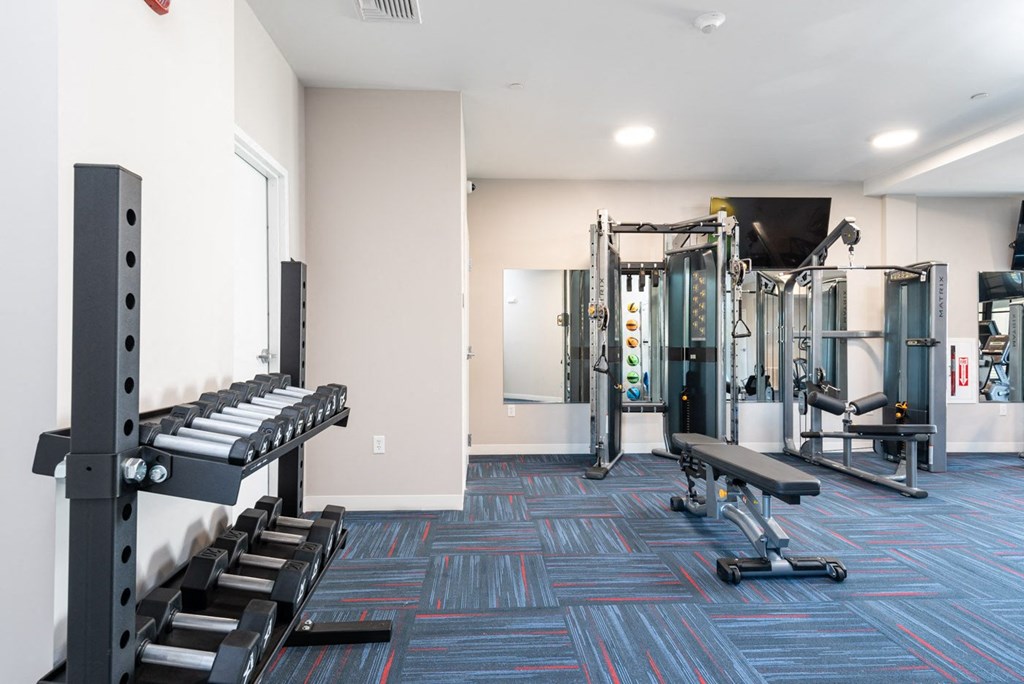 View of the fitness room with free weights at Millside Apartments