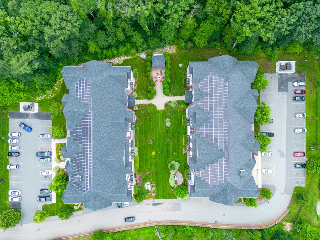 a birds eye view of the roofs of two buildings and a parking lot