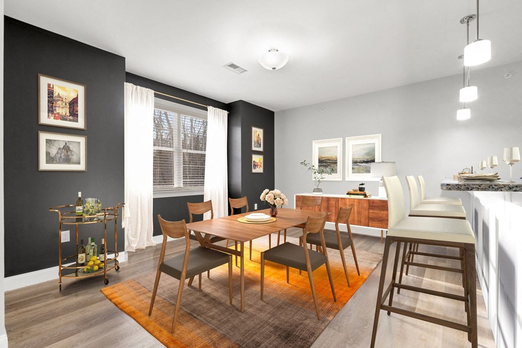 Ashland woods apartments in MA dining area with accent wall and vinyl flooring, virtually staged