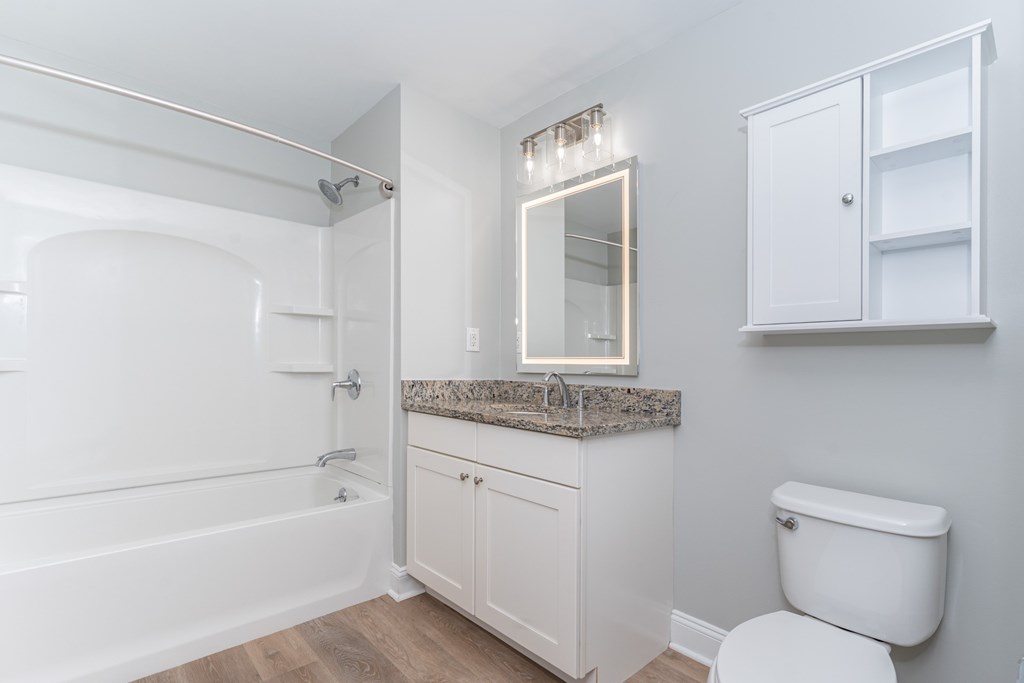 A white bathroom with a tub, toilet, and sink.