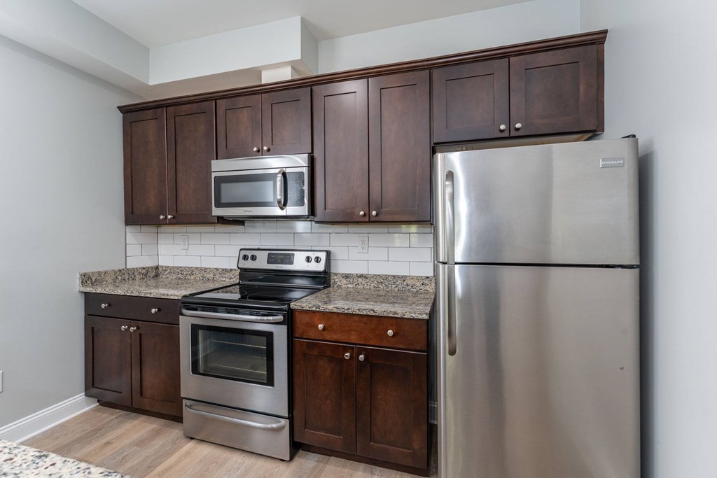 A kitchen with a stainless steel refrigerator, oven, and microwave.